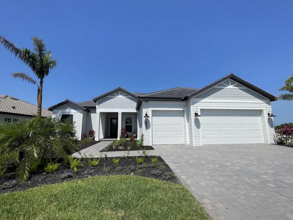 semi-custom new construction home at gran place at wellen park by sam rogers - the destin home model front entrance home with 3 car garage types of homes in wellen park
