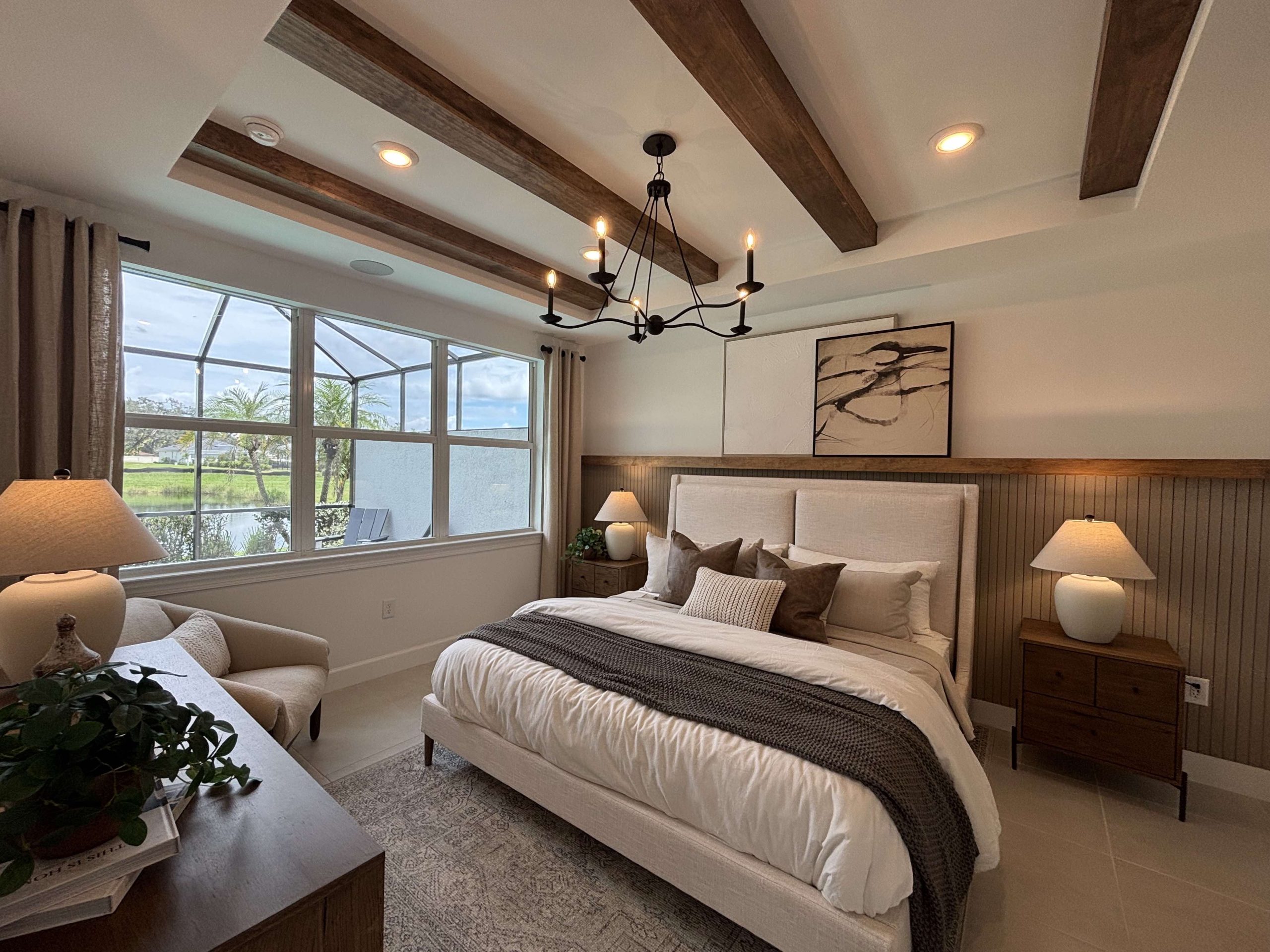 master bedroom with kingsize bed, overhead wooden beams, mocca color scheme and lots of natural light