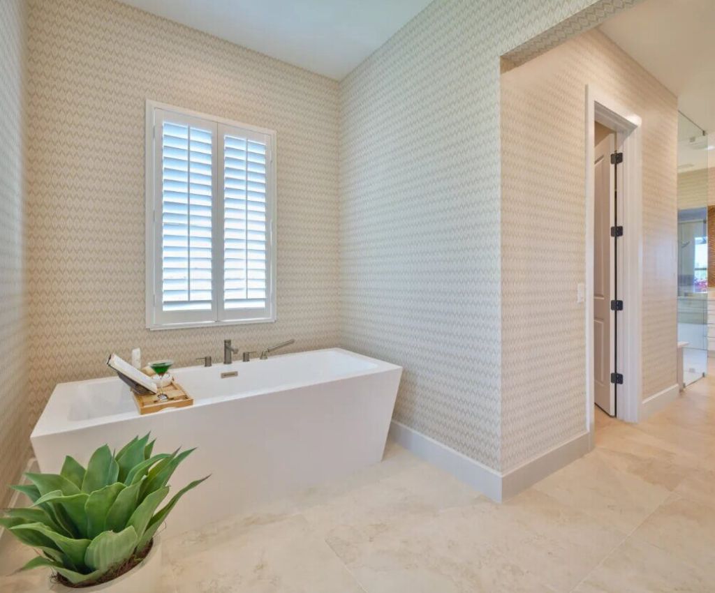 custom designed bathroom shows a dual side bath tub tucked behind a privacy wall for a cozy feel.