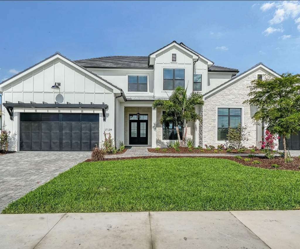 exterior of the monterey 2 home front with large garage doors, multiple floors, and pointed roofs.